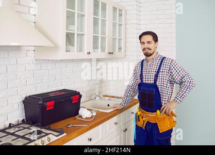 Portrait of happy plumber pose in client home Stock Photo