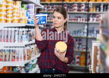 Woman is choosing with paint for repair Stock Photo