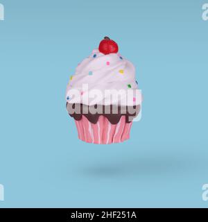 Colorful cupcake flying isolated on a bright blue background. Minimal celebration party concept. Stock Photo