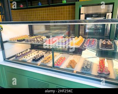 Various colored cakes on plates. Sweet desserts. Photo Stock Photo