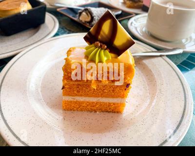 Various colored cakes on plates. Sweet desserts. Photo Stock Photo
