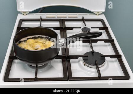 whole boiled potatoes in a saucepan on the stove. High quality photo Stock Photo