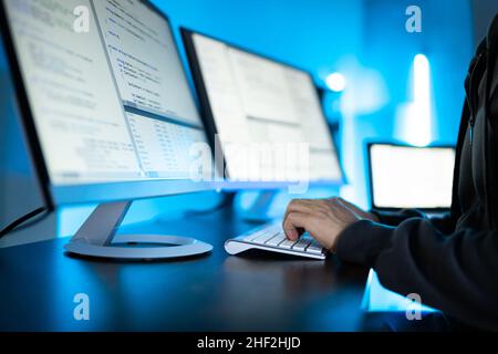 Hacker Using Computer To Write Cyber Security Exploit Software Program Stock Photo