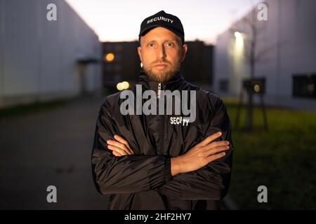 Portrait Of Young Male Security Guard Standing Arms Crossed Stock Photo