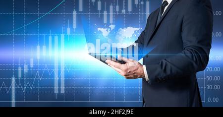 Businessman holding a tablet and reviewing global economic data. Stock investor and broker reviewing stocks Stock Photo
