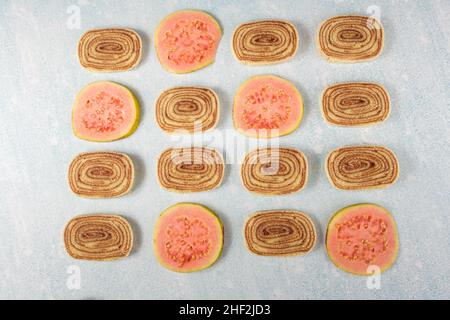 Bolo de rolo and guava slices on a blue and white background. Stock Photo