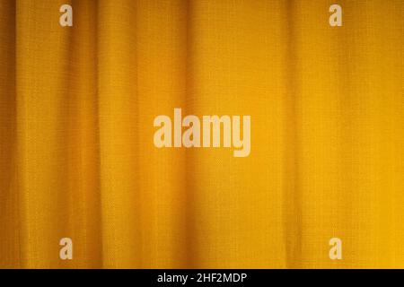 Close-up of fabric yellow curtains with folds . Abstract background, curtain, drapes gold fabric. Stock Photo