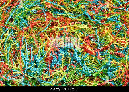 Color shredded confetti paper gift box filler. Abstract bright colored background. Stock Photo