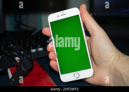 smartphone with green screen on a desk Stock Photo