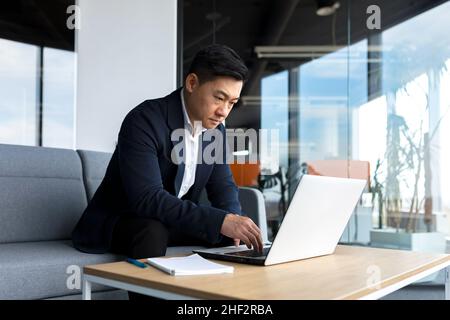 Sad businessman working on a laptop in the office, frustrated and pensive, working in thought Stock Photo