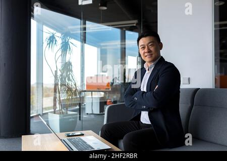 Successful businessman boss happy looking at camera and smiling, working in modern office Stock Photo