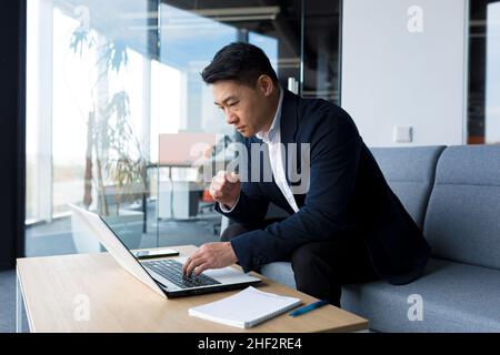 Sad businessman working on a laptop in the office, frustrated and pensive, working in thought Stock Photo
