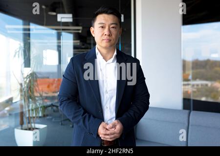 Portrait of successful business man boss Asian serious man looking at camera in modern office Stock Photo