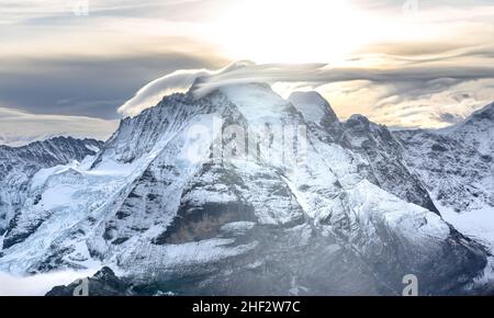 View of the famous peaks Jungfrau, Mönch and Eiger from the mountain Schilthorn in the Swiss Alps Switzerland at sunrise with dramatic clouds and fres Stock Photo
