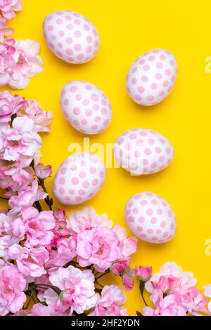 Easter background with polka dot paschal eggs, flat lay with cherry blossom tree branches. Spring season. Minimal design, festive floral greeting card Stock Photo