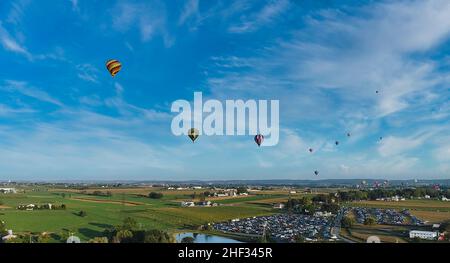 Aerial View of Many Hot Air Balloons Flying Across Rural Countryside During a Balloon Festival Stock Photo