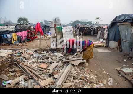 Ghaziabad, India. 13th Jan, 2022. Women seen picking up material from ramshackle place in a derelict area.Poor people living in urban slum area of vasundhara, Urban poverty in India is now over 25 percent, close to 81 million people in urban areas live below the poverty line. Several reports indicate that the national level of around 150-199 additional million people will become poor due to COVID-19 crisis, while those who are already poor will be pushed deeper into poverty. (Photo by Pradeep Gaur/SOPA Images/Sipa USA) Credit: Sipa USA/Alamy Live News Stock Photo