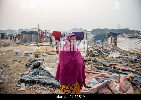 Ghaziabad, India. 13th Jan, 2022. A woman seen covering her face with shawl living in grim poverty in a derelict area inhabited by cluster of slums.Poor people living in urban slum area of vasundhara, Urban poverty in India is now over 25 percent, close to 81 million people in urban areas live below the poverty line. Several reports indicate that the national level of around 150-199 additional million people will become poor due to COVID-19 crisis, while those who are already poor will be pushed deeper into poverty. (Photo by Pradeep Gaur/SOPA Images/Sipa USA) Credit: Sipa USA/Alamy Live News Stock Photo