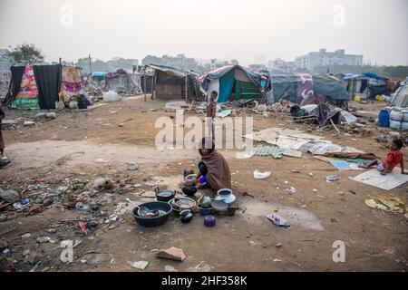 Ghaziabad, India. 13th Jan, 2022. A slum dweller woman seen washing utensils in an unhygienic space in front of slum clusters.Poor people living in urban slum area of vasundhara, Urban poverty in India is now over 25 percent, close to 81 million people in urban areas live below the poverty line. Several reports indicate that the national level of around 150-199 additional million people will become poor due to COVID-19 crisis, while those who are already poor will be pushed deeper into poverty. Credit: SOPA Images Limited/Alamy Live News Stock Photo