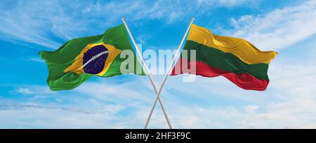 two crossed flags Brazil and Lithuania waving in wind at cloudy sky ...