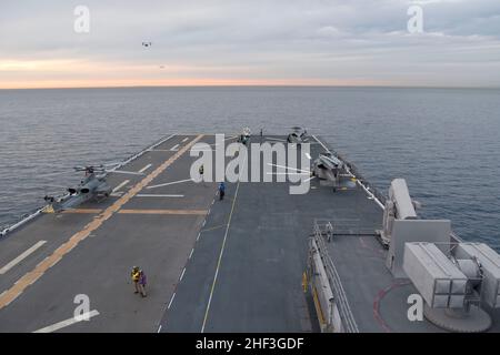 220110-N-XN177-1048 (Jan. 10, 2022) PACIFIC OCEAN An AH-1Z Viper and MH-60S Knighthawk helicopters attached to the “Wild Cards” of Helicopter Sea Combat Squadron (HSC) 23 conduct flight operations aboard aboard amphibious assault ship USS Tripoli (LHA 7), Jan. 10. Tripoli is an America-class amphibious assault ship homeported in San Diego. (U.S. Navy photo by Mass Communication Specialist 1st Class Peter Burghart) Stock Photo