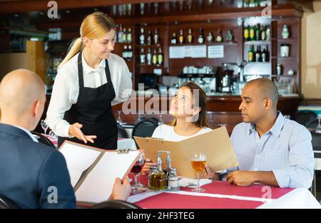 Business colleagues making order with waitress in pizza restaurant Stock Photo