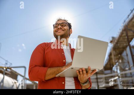 Happy African engineer standing at industrial site Stock Photo