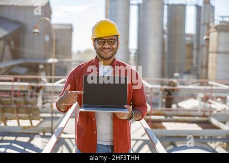 Multiethnic engineer working with laptop at plant Stock Photo