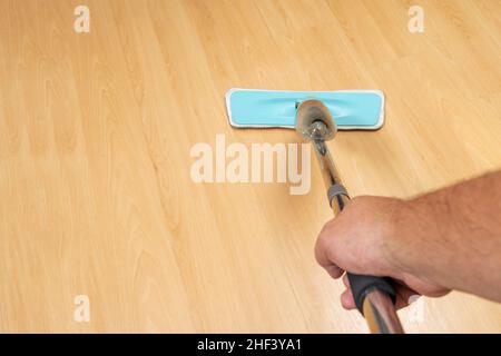 Man mopping a light wooden floor. Copy space. Stock Photo