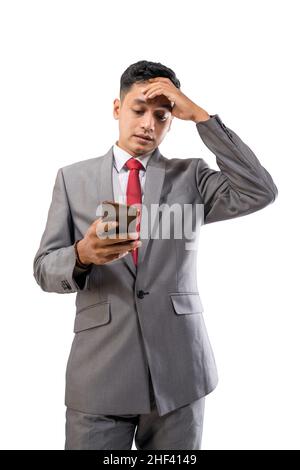 depressed businessman holding his forehead while using his mobile phone Stock Photo