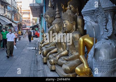 A row of different Buddha statues is placed outside a shop for Buddhist ritual objects in Bamrung Muang Road, Bangkok, Thailand
