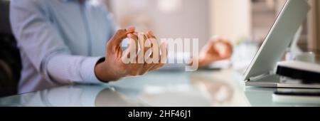 African American Male Meditation In Office Near Computer Stock Photo