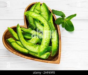 Dry chunks of pomelo on a plate on a white wooden background Stock Photo