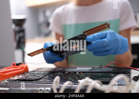 Repairman hands hold pc microcircuit, close-up, blurry. Broken computer part, device soldering, repair processor Stock Photo