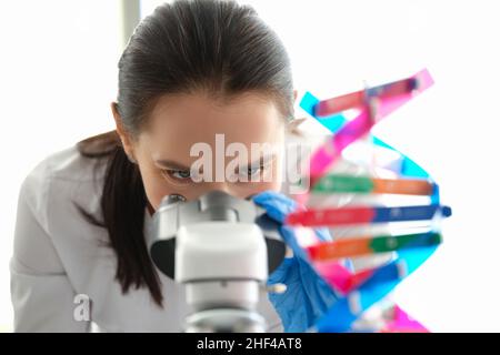 A woman biologist looks through a microscope, eyes close-up Stock Photo