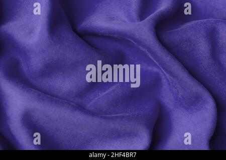 Fabric with waves colored in violet color of the year 2022. Trendy color very peri. Fabric backdrop, cloth texture, view from above. Stock Photo