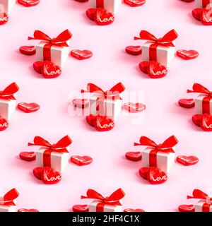 Gift box with bright red bow ribbon, hearts and Love words repeat seamless pattern on light pink background. Valentines day, Birthday, Mothers day sur Stock Photo