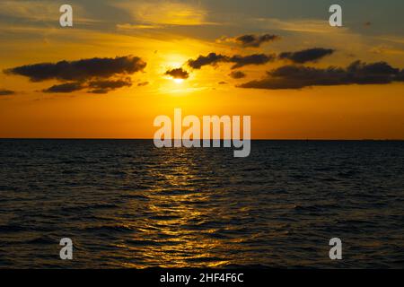 Sunset background. Sunset over the sea and silhouette of clouds background photo. Stock Photo