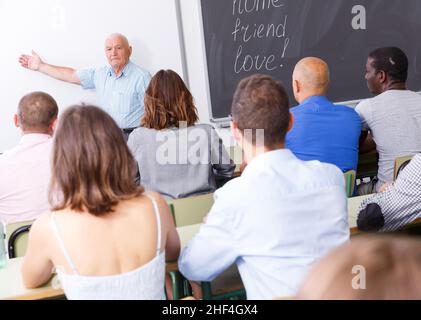 Mature teacher standing in front of students Stock Photo