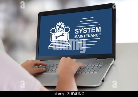 Woman using a laptop with system maintenance concept on the screen Stock Photo