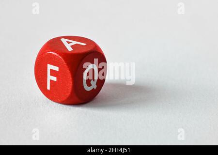 Wooden dice with the Word FAQ on white background - Concept of frequently asked question Stock Photo