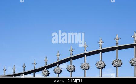 A iron grille of a house fence. ornamental artistic details and spearhead or arrowhead finish. security concept. copy space. Stock Photo