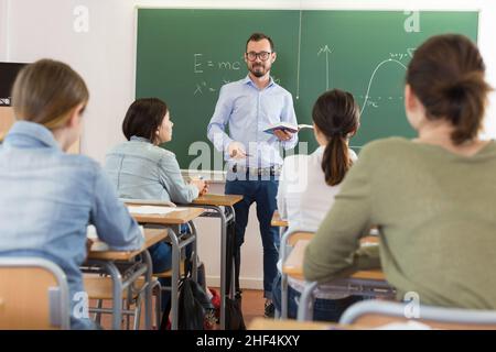 Man teacher is giving interesting lecture for students Stock Photo