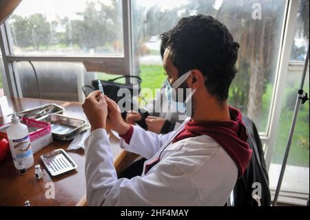 Tunis, Tunisia. 13th Jan, 2022. Tunis, Tunisia. January 13, 2021: Tunisians receives a dose of the Covid-19 vaccine during an ongoing mass vaccination campaign to contain the current explosion of Covid-19 cases and the spread of the Omicron variant. Since December 22, a compulsory vaccination pass has been introduced to access public transport and for entry to public buildings and shopping centres (Credit Image: © Hasan Mrad/IMAGESLIVE via ZUMA Press Wire) Stock Photo