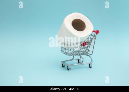 Toilet paper in the shopping trolley. Concept of high demand and shortage of toilet paper in the market. Stock Photo