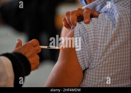 Tunis, Tunisia. 13th Jan, 2022. Tunis, Tunisia. January 13, 2021: Tunisians receives a dose of the Covid-19 vaccine during an ongoing mass vaccination campaign to contain the current explosion of Covid-19 cases and the spread of the Omicron variant. Since December 22, a compulsory vaccination pass has been introduced to access public transport and for entry to public buildings and shopping centres (Credit Image: © Hasan Mrad/IMAGESLIVE via ZUMA Press Wire) Stock Photo