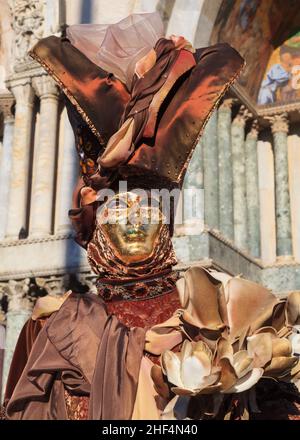 Woman in flamboyant  fancy dress costume and gold mask, Venice carnival, Carnevale di Venezia, Italy Stock Photo