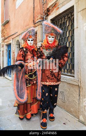 Man and woman in colourful historic oriental fancy dress costumes, pose at Venice Carnival, Carnevale di Venezia, Italy Stock Photo