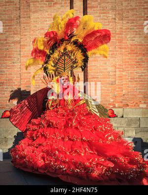 Woman in beautiful vibrant red, feathered historic Phoenix fancy dress costume, Venice carnival, Carnevale di Venezia, Italy Stock Photo