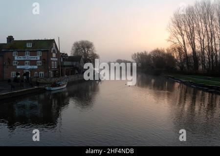 Wareham, Dorset UK. 14th January 2022. UK weather: a cold start at Wareham, Dorset as fog hangs over the River Frome in the morning. Boats, yachts moored on the river Frome. Credit: Carolyn Jenkins/Alamy Live News Stock Photo